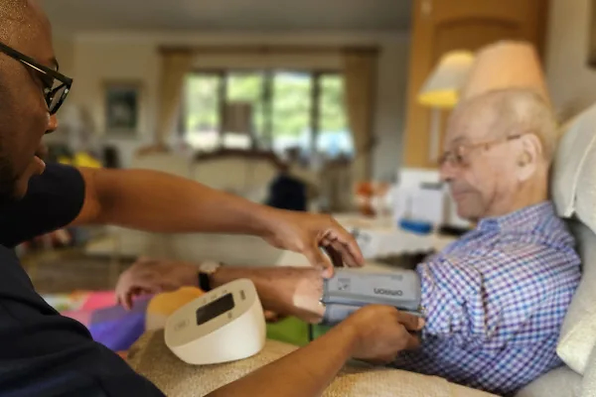 Fresh Springs Care carer taking an elderly man's blood pressure in a home setting in Bristol