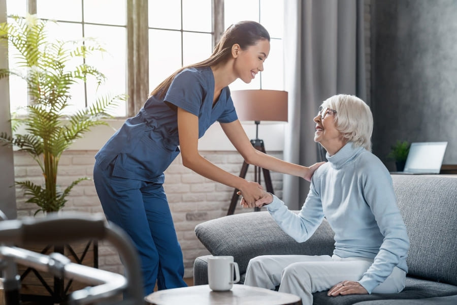 Why Families Trust Fresh Springs Care for Compassionate Home Support in Highworth Female carer smiling and supporting an elderly woman in a cosy living room in Highworth